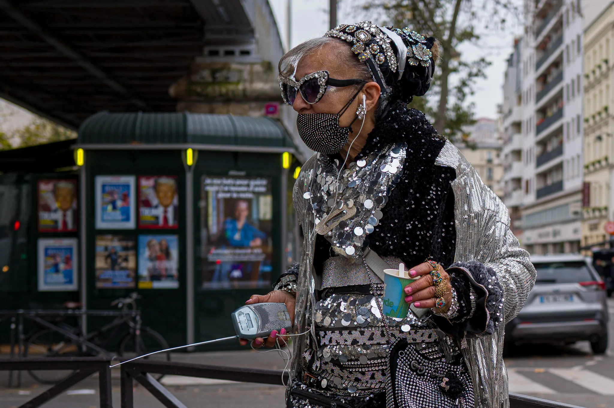Femme pailletée dansant au pied du métro La-Motte-Picquet, café et transistor en main.