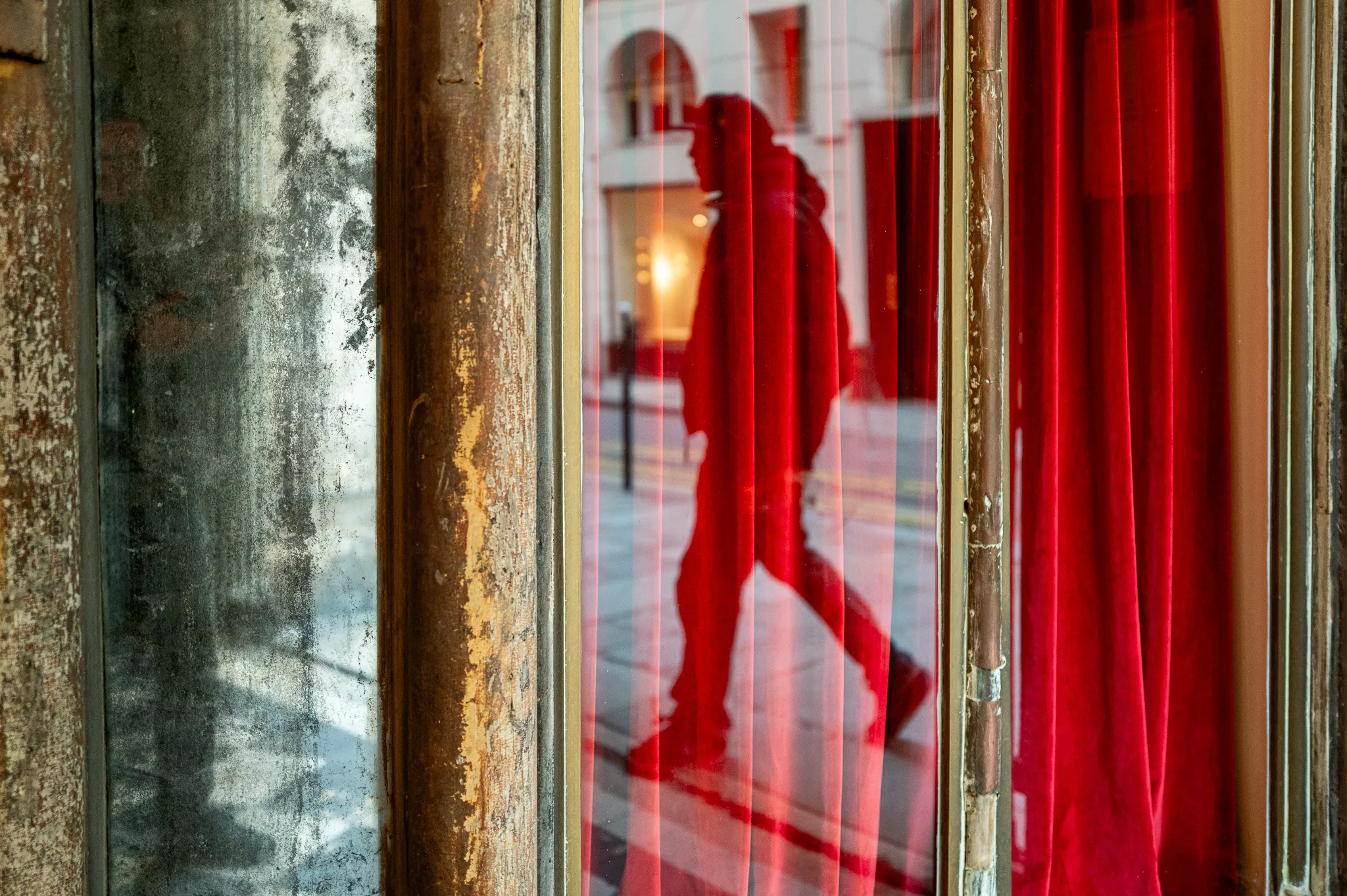 Reflet d'un homme dans la vitrine aux rideaux rouges de la boutique Louboutin, galerie Véro-Dodat, Paris