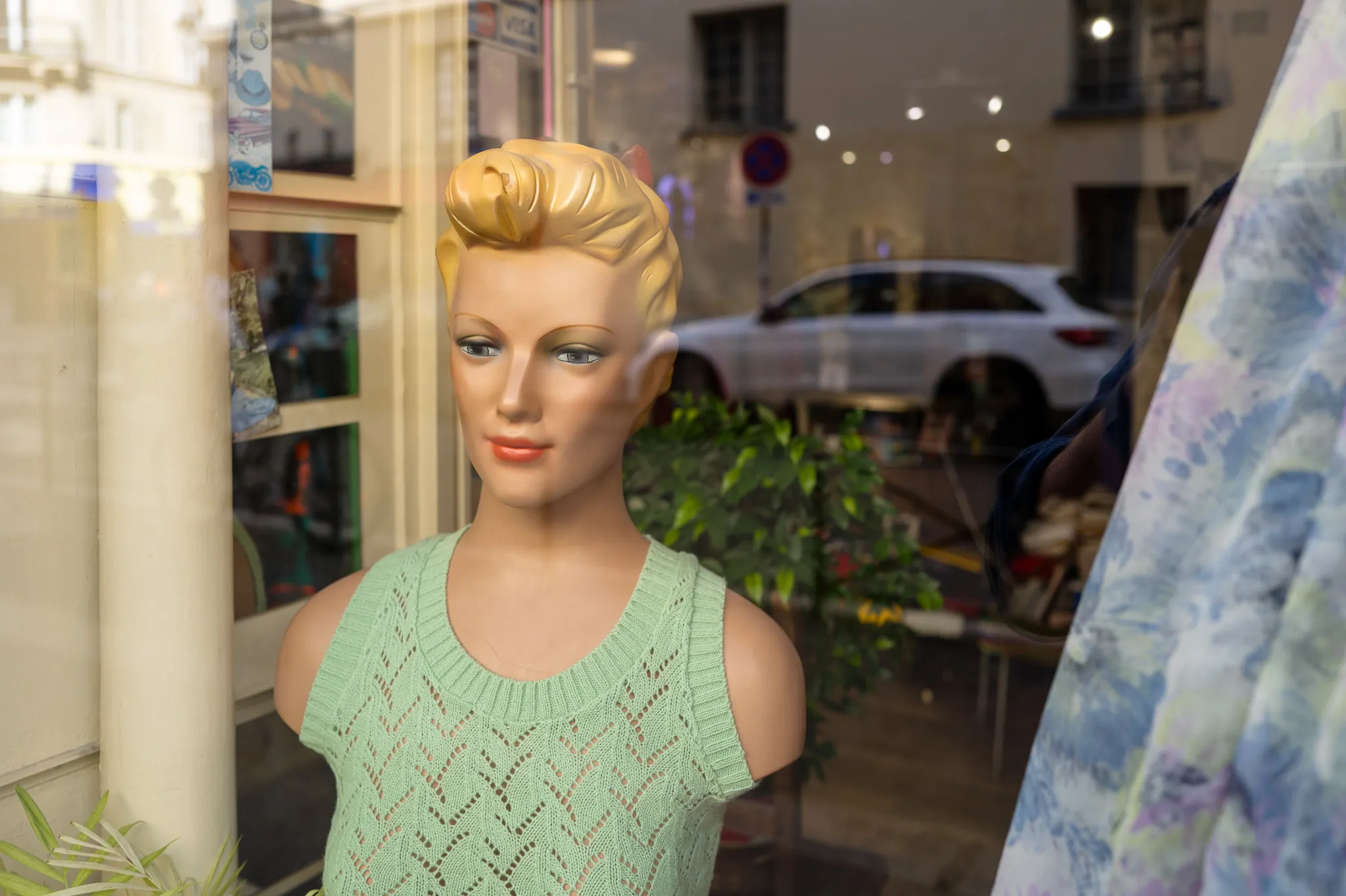 Autre mannequin figé dans une vitrine rétro, posture figée et décor des années 50.