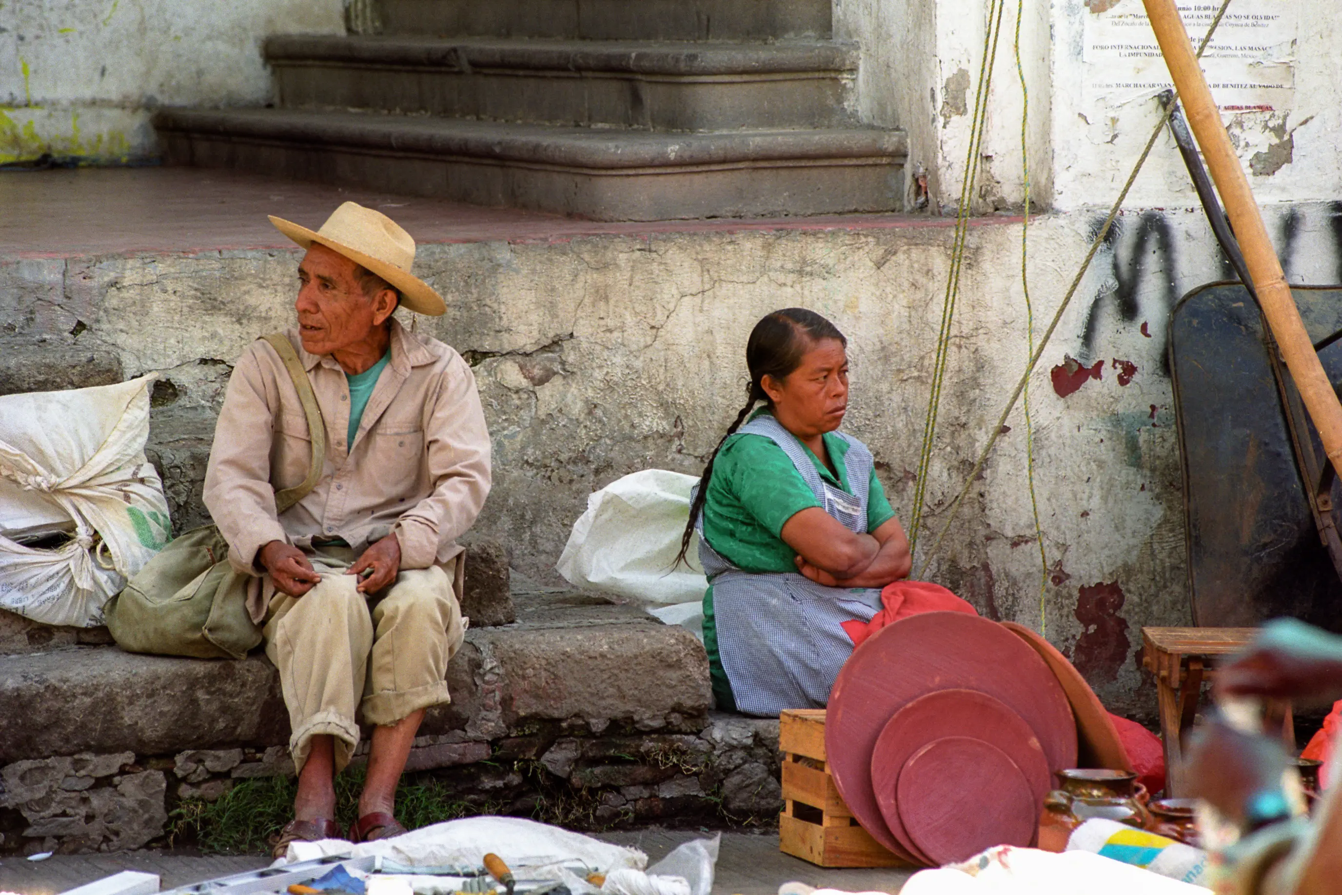 Un homme et une femme assis côte à côte sur le marché de Tepoztlán regardent dans des directions opposées