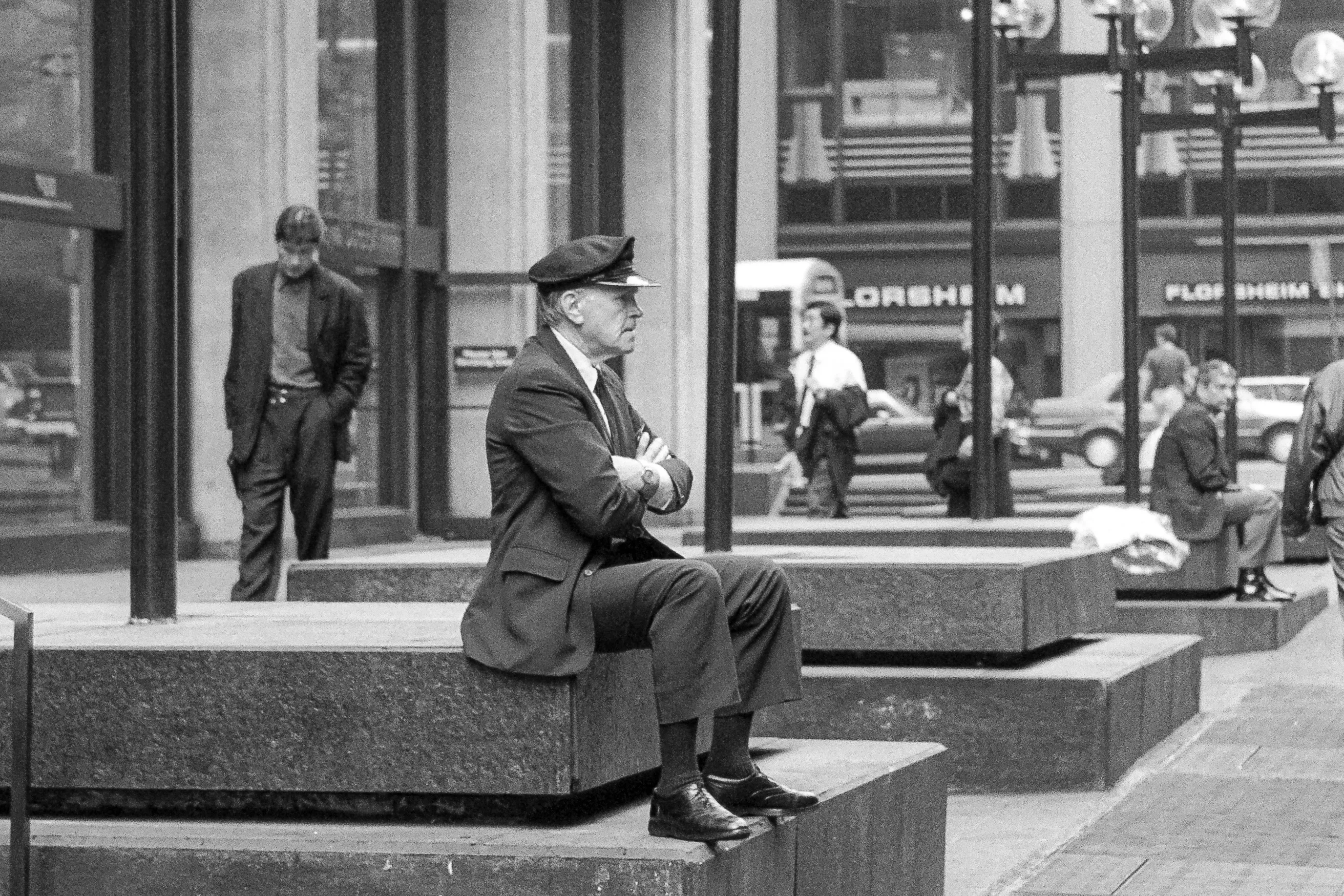 Employé en uniforme assis sur un banc devant l'entrée d'un immeuble de bureaux à New York pendant sa pause, en octobre 1990.