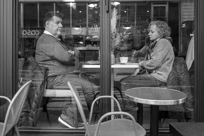 Deux personnes assises face à face dans un café, l'air peu enthousiaste