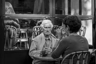 Deux personnes assises face à face à la terrasse d'un café