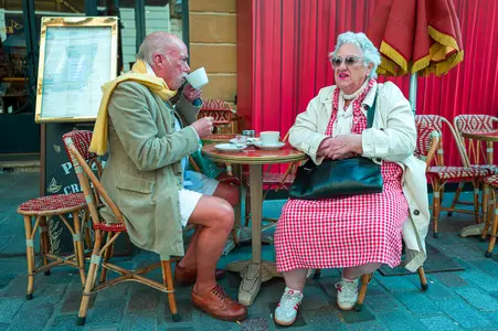 Un homme et une femme assis à la terrasse d'un café, dans une ambiance très britannique