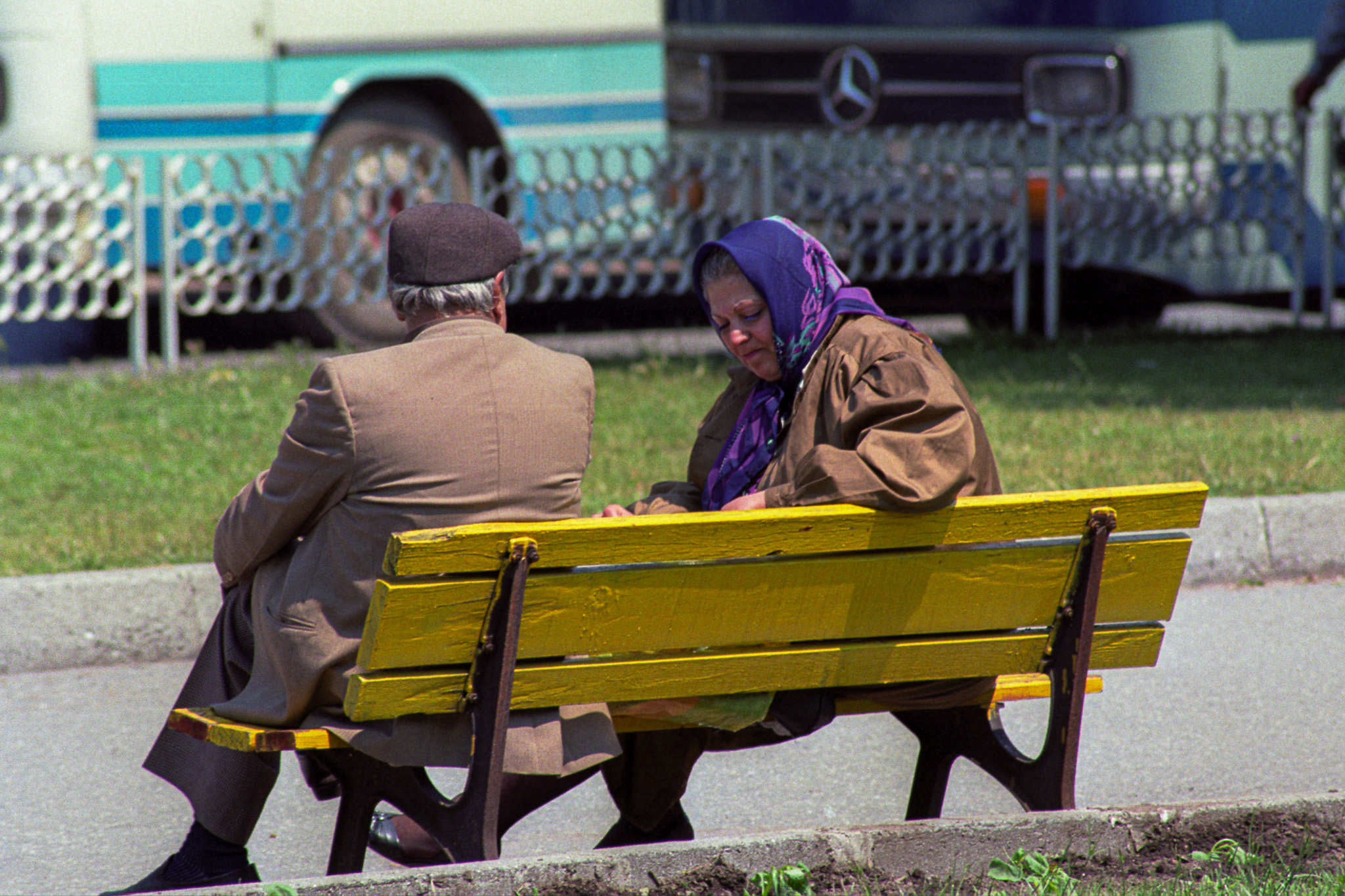 Un couple entre deux ages parlent assis sur un banc