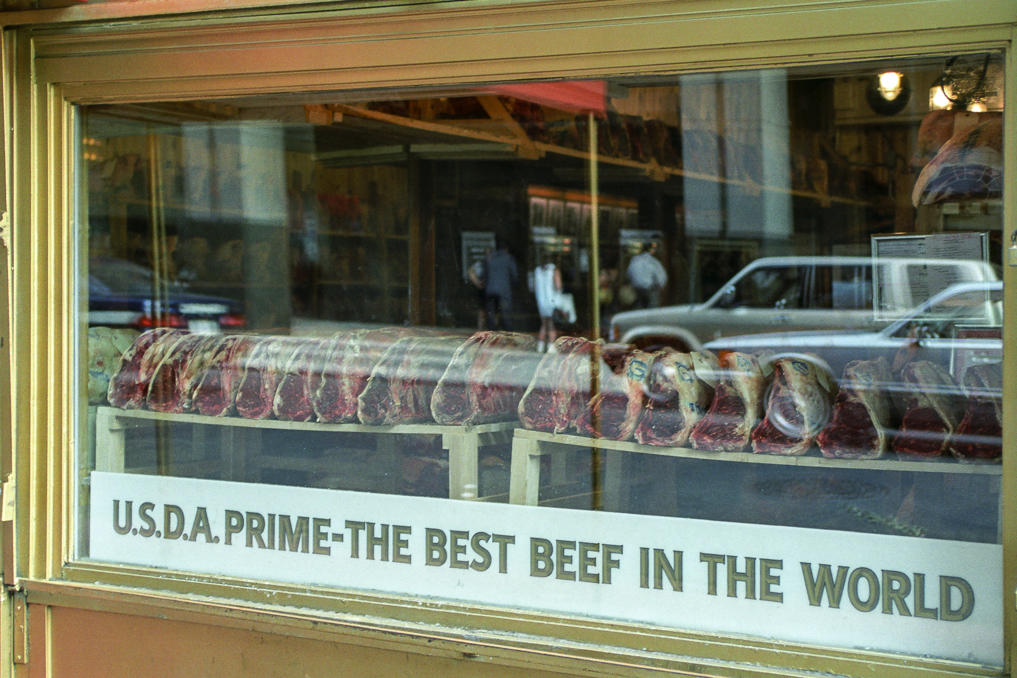 Vitrine de Gallagher’s Steakhouse à New York en 1995, rangées de viandes maturées et inscription The Best Beef in the World.