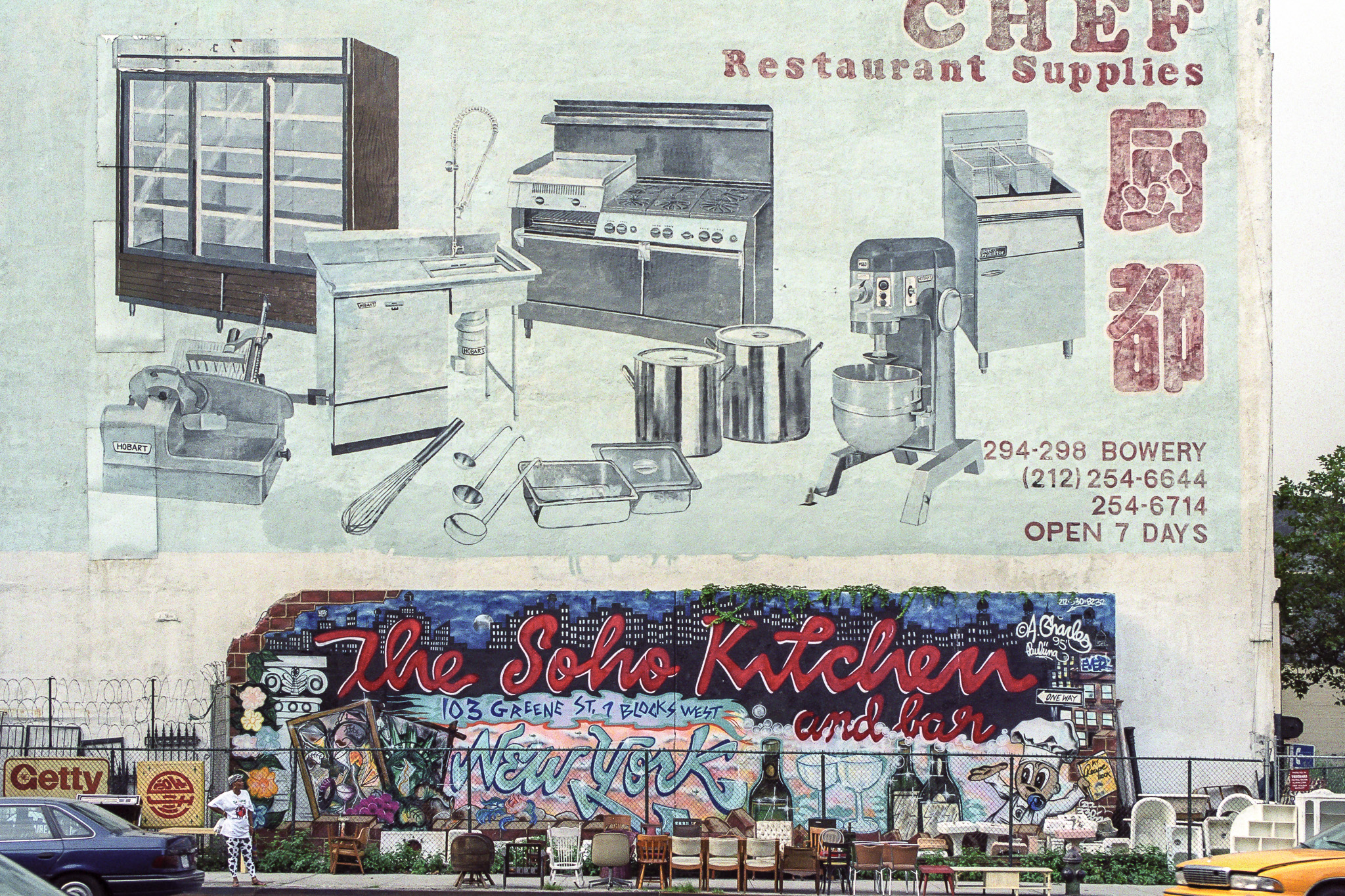 Mur peint à New York représentant du matériel de cuisine, fresque colorée de bar en dessous, meubles usés disposés sur le trottoir.