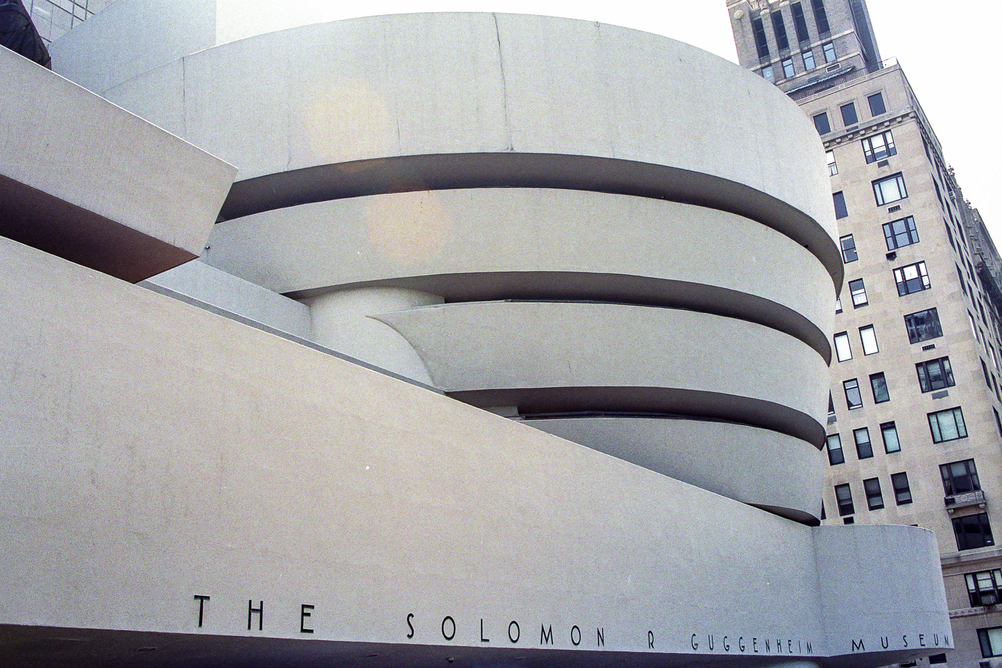 Musée Guggenheim à New York, spirale blanche de Frank Lloyd Wright contrastant avec les immeubles voisins.