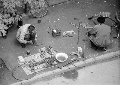 Pompes, rustines et outils sont disposés autour des réparateurs de bicyclettes.