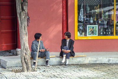 Deux femmes font une pause devant une boutique de souvenirs de Huaqing.