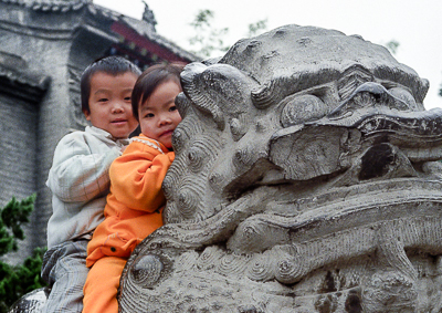 Les enfants s’abritent derrière la tête grimaçante du lion gardien.