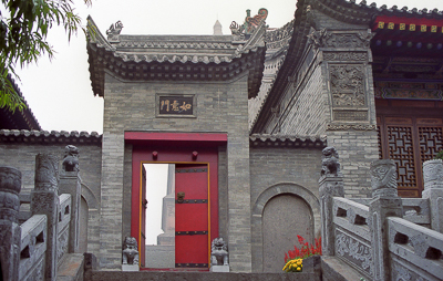 La porte Ruyi, encadrée de briques grises, de sculptures et de lourds battants rouges.