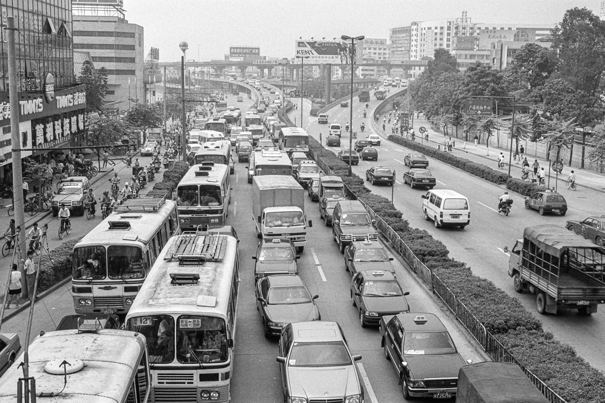 Vue d'une grande avenue à Canton en 1995, encombrée de voitures, bus et camions, témoignant de la montée en puissance de l’automobile.