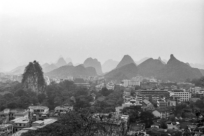 Vue sur les bâtiments de Guilin dominés par une succession de pitons karstiques.