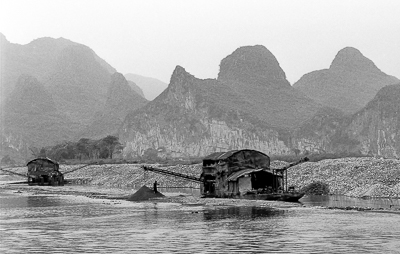 Embarcation couverte sur la rivière Li, devant de hauts reliefs karstiques.