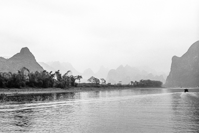 La rivière Li s’étend entre les rives boisées et les montagnes estompées par la brume.