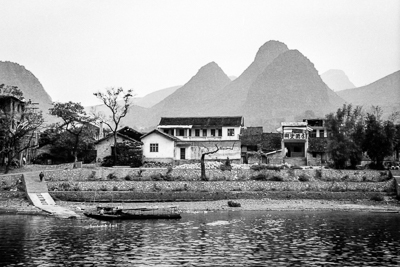 Maisons et petite embarcation sur une rive de la rivière Li.