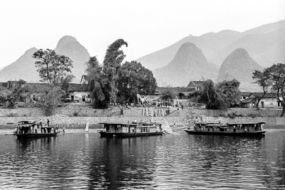 Maisons d’un village et bateaux de croisière au bord de la rivière Li.