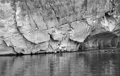 Un portefaix au pied de l'immense paroi rocheuse sur la rivière Li.