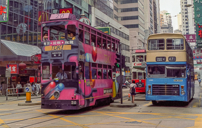 Deux tramways à impériale se croisent dans les rues de l’île de Hong Kong.