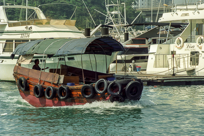 Une embarcation de travail passe parmi les bateaux de plaisance.