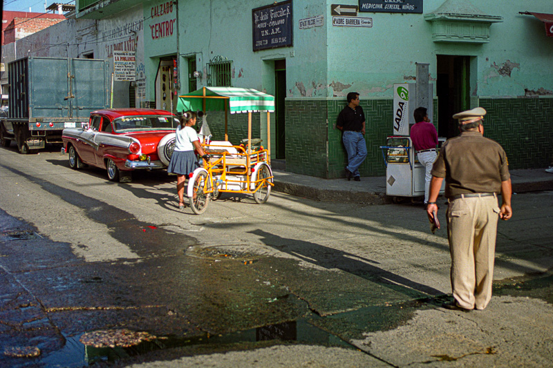 Vieilles voitures et commerces dans une rue de Cuautla.