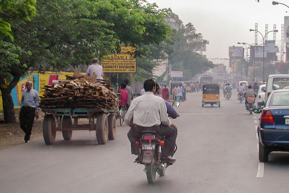 Une charrette, une moto et des voitures se partagent la route à Chennai.