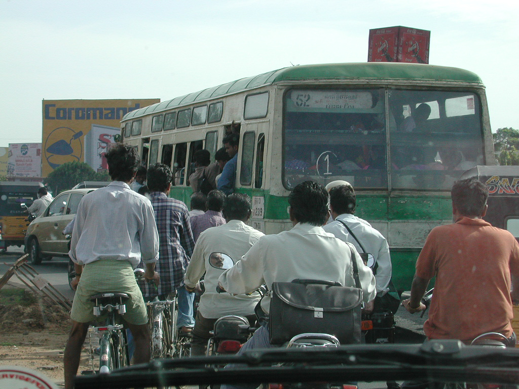 Motos et scooters regroupés derrière un bus.