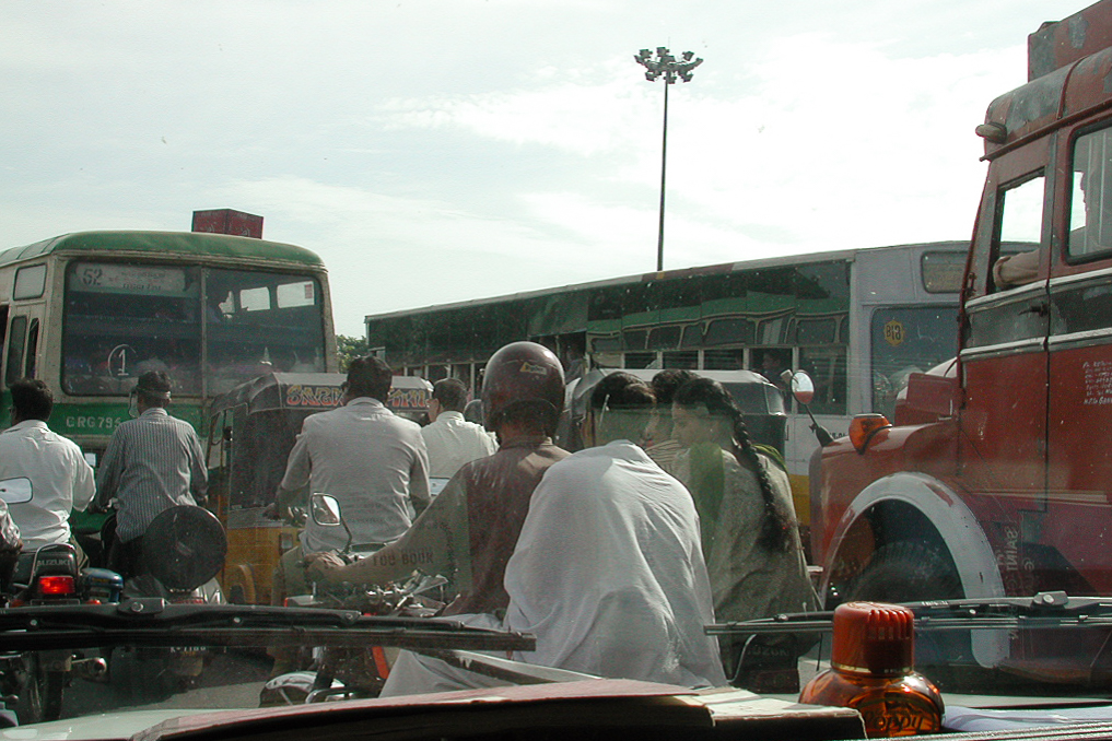 Deux-roues serrés entre un bus et un camion.