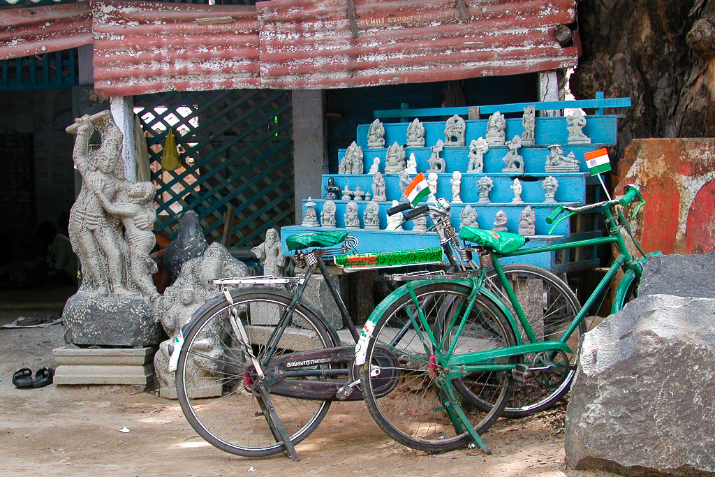 Des bicyclettes devant l'étalage d'un atelier de sculpture.