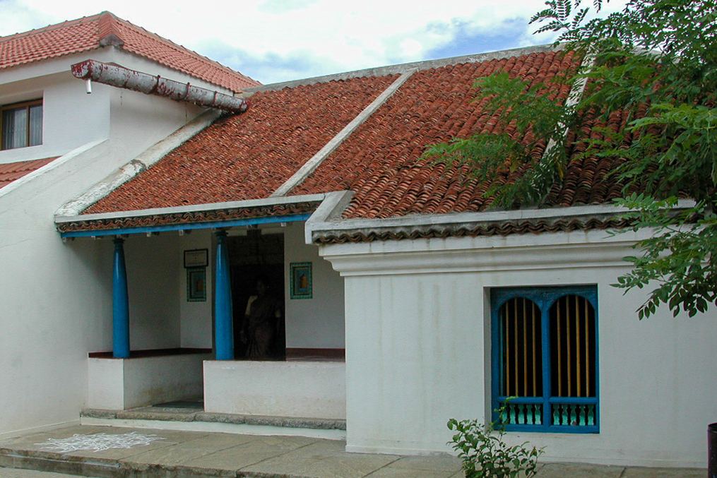 La maison du tisserand, aux murs blancs et au toit de tuiles rouges.