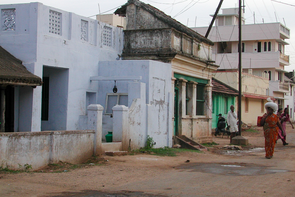 Maisons blanches et colorées le long d'une rue calme.