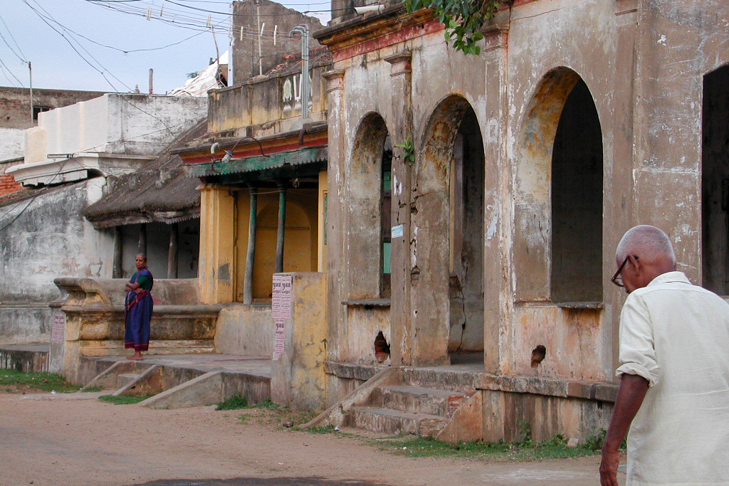 Un passant devant les arcades d'une maison ancienne.