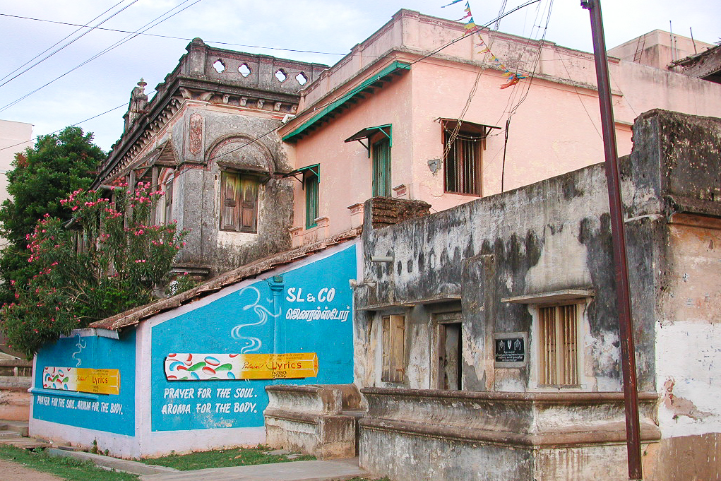 Maisons anciennes et publicité peinte au bord de la rue.