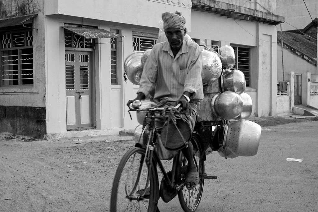 Un cycliste transporte un improbable chargement de casseroles.