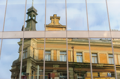 Façade ancienne reflétée dans les vitres d’un immeuble contemporain à Prague