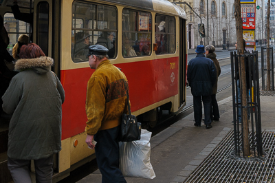 Voyageurs montant dans un tramway rouge et crème à Prague
