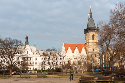 Église et bâtiments anciens derrière les arbres d’un parc de Prague