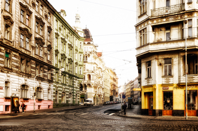 Rue courbe du centre de Prague avec rails de tramway et façades anciennes