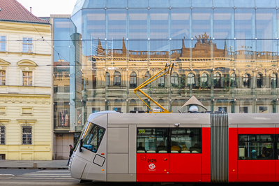 Tramway moderne devant une façade vitrée aux reflets d’architecture