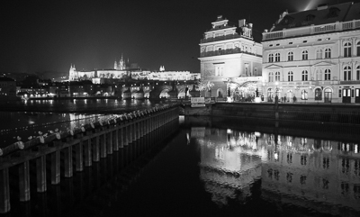 Bâtiments éclairés et reflets sur la Vltava de nuit