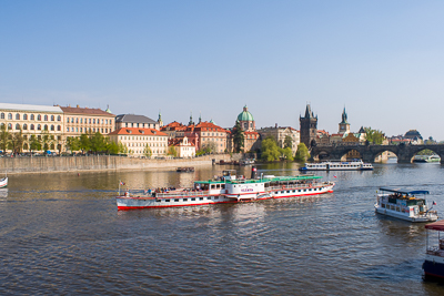 La Vltava avec bateaux, coupoles et pont Charles dans le lointain