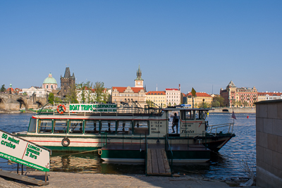 Bateau touristique sur la Vltava devant les façades de Prague