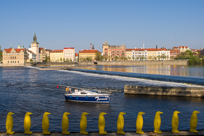 Quais de la Vltava avec bateau et rangée de protections jaunes