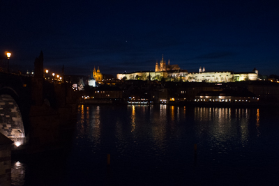 Château de Prague illuminé au-dessus de la Vltava à la nuit tombée
