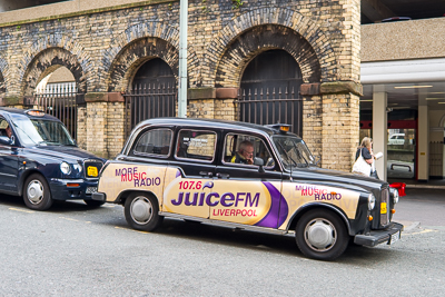 Taxi aux couleurs de Juice FM dans une rue de Liverpool