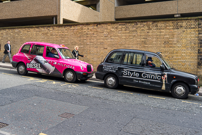 Deux taxis décorés stationnés devant un mur de briques à Liverpool