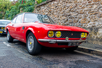 Ferrari rouge parmi les voitures anciennes rassemblées à Épône