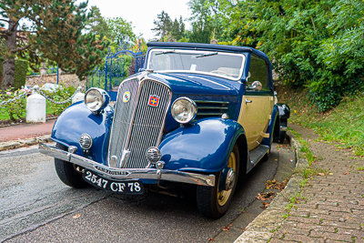 Berline ancienne bleu et crème stationnée près d’un jardin à Épône