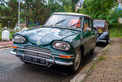 Voiture française ancienne vert foncé garée dans une rue d’Épône